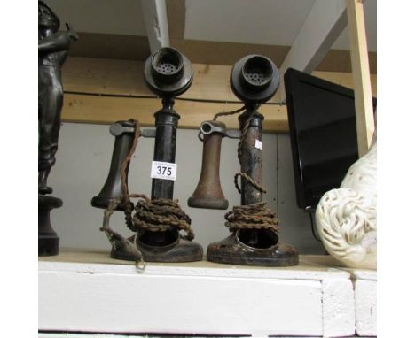 2 old candlestick telephones, both missing dials.