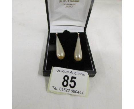 A pair of vintage pendant earrings with gold shepherd's hook in a cone shape.