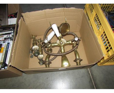 A vintage brass bathroom tap set with shower attachment.