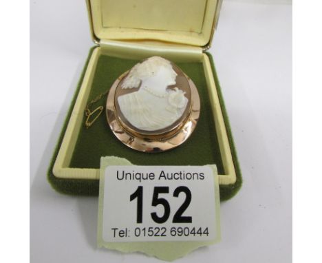A finely carved cameo of a Roman Goddess in a rose gold mount with attached safety chain.