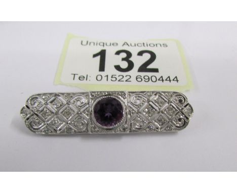 An Art Deco diamond set brooch with central amethyst set in platinum.