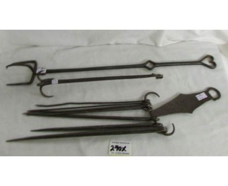 A collection of 18th century hearth accoutrements featuring spit hanger, roasting fork, skewer hanger with skewers including 