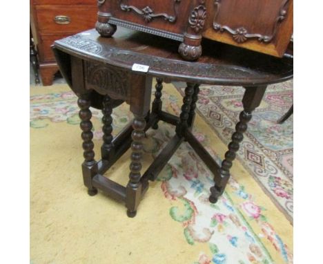 An oak barley twist gate leg table with carved edge.