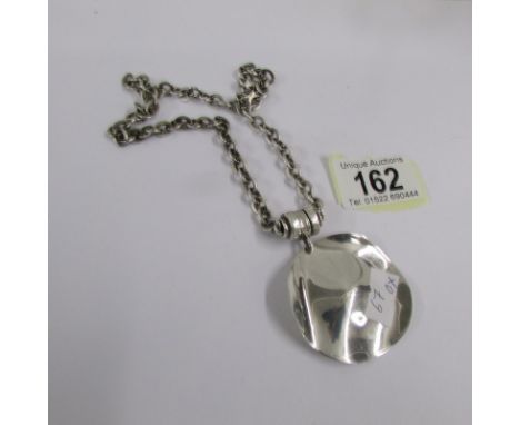 A heavy silver pendant and chain.