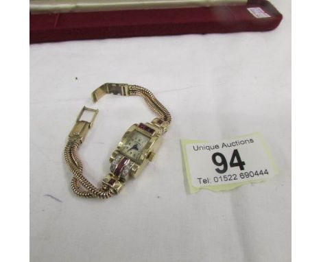 An Art Deco diamond and ruby ladies wrist watch in gold, approximate total weight 29.9 grams.