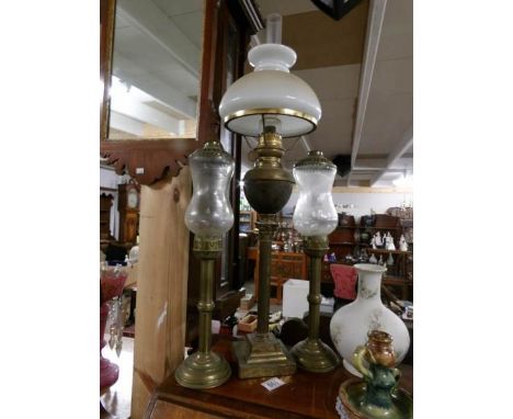 A brass oil lamp and 2 brass candle lamps.