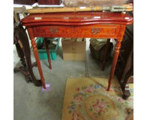 A mahogany fold over card table on reeded legs.