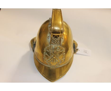 A FIREMANS BRASS HELMET AND MANTLE CLOCK. A brass Firemans helmet with chinstrap and liner, the comb being decorated with dra