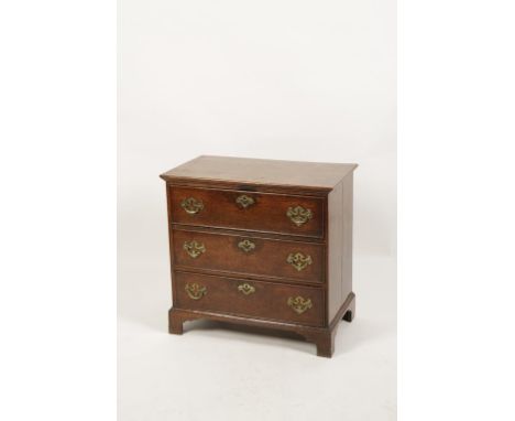 A GEORGE III OAK CHEST OF DRAWERS, the rectangular top above three short drawers with brass handles and key escutcheons, on s