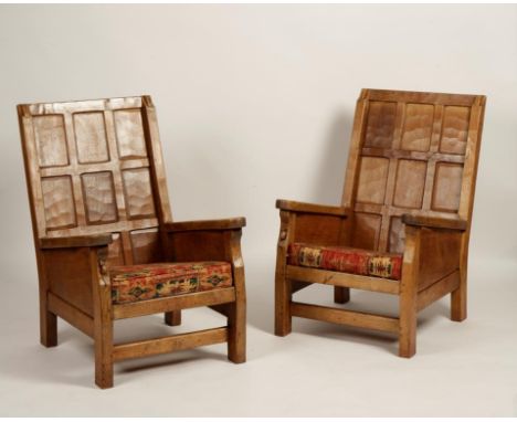 •ROBERT THOMPSON: A PAIR OF OAK PANELLED BACK ARMCHAIRS with nine panel adzed backs and shaped arms above panelled sides and 