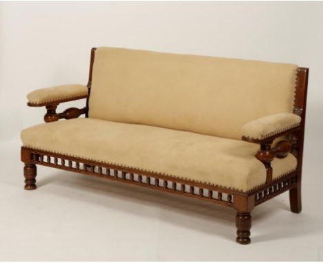 AN AESTHETIC PERIOD TURNED OAK AND SUEDE UPHOLSTERED SETTEE, the broad seat with raised back and arms on turned supports with