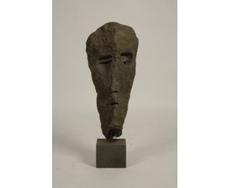 20th Century School "Stone Face", carved boulder of grey stone, mounted on a slate cube base, 36" high. See illustration