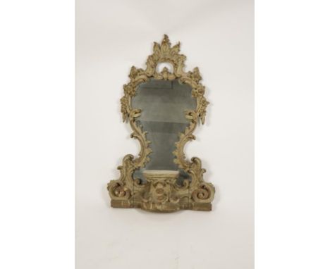 A CARVED AND PAINTED ROCOCO STYLE CARTOUCHE MIRROR, the waisted plate in an elaborate scrolling and foliate carved surround, 