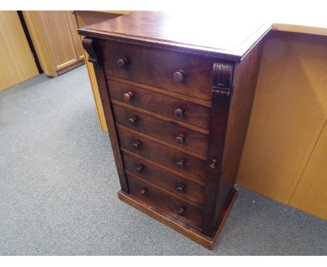 A 19th century mahogany Wellington Chest, the five drawers with bun handles, locking bar with key, on plinth base, (upper sur