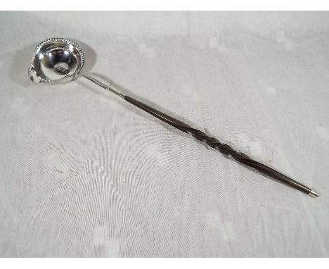 A 19th century toddy ladle centred with a silver coin, twist handle - Est £40 - £60