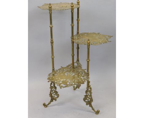 A brass three tier whatnot or pan stand, each pierced shelf decorated with butterflies on reeded and turned supports, 77cm hi