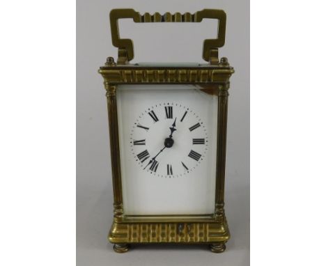 An early 20thC French brass carriage timepiece, with a white enamel dial and shaped case, 15cm high