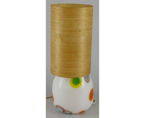 A retro style white opaque and coloured lamp base, decorated with spots and with a period shade, 41cm high