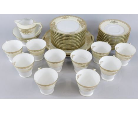 A Noritake Art Deco style porcelain part tea service, decorated in gilt with flowers on a blush ivory ground