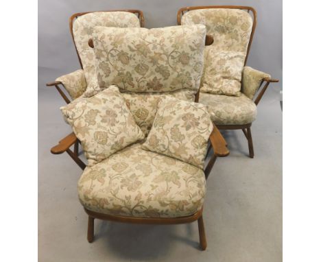Three similar Ercol type open armchairs, each with loose cushions to the back, armrests and seat, on turned legs The upholste