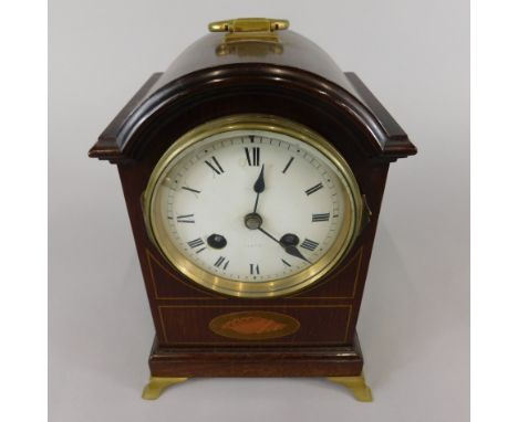 An Edwardian mahogany and marquetry mantel clock, with brass handle and splayed ogee feet, the white enamel dial decorated wi