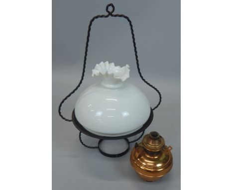 A brass and wrought iron ceiling mounted oil lamp, with opaque glass shade