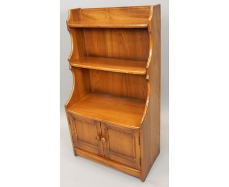 An Ercol type mid coloured elm bookcase, with two shelves, shaped sides and two panelled doors, 61cm wide
