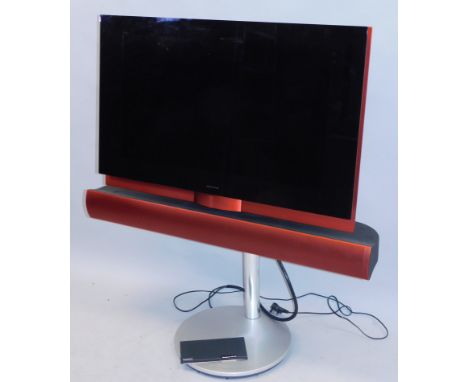 A Bang & Olufsen red and black television, with beocord controller, sound bar or speaker, 32" screen