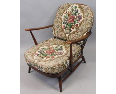 An Ercol cottage style open armchair, with a wheel back, upright rails and turned legs The upholstery in this lot does not co