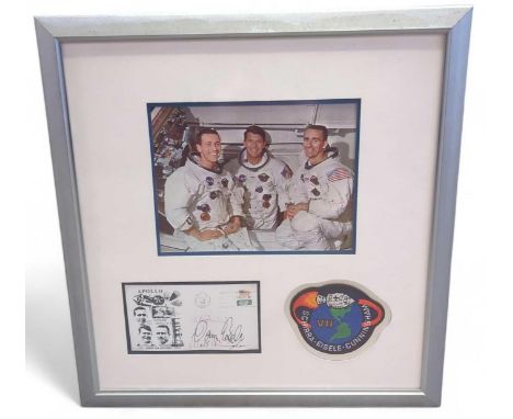 A framed and glazed display featuring an image of the Apollo 7 crew, a copy of a signed first day cover and an embroidered pa