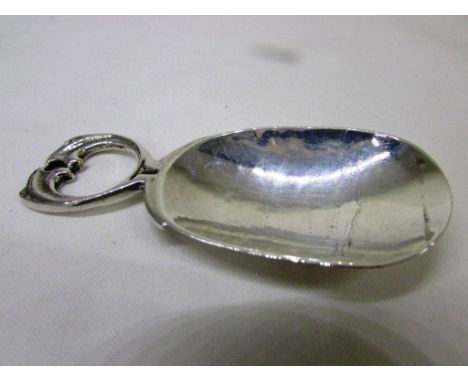 An Arts and Crafts style silver caddy spoon by Albert Edward Jones, hammered bowl, handle formed as two stylized leaves, mark