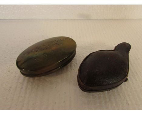An oval brass snuff box marked THOMAS PHILLIPS TAILOR. 1883 (length 7cm); and a cased pipe carved with two dogs (length of pi