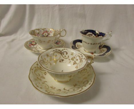 Two Rockingham porcelain tea cups and saucers, the first example white ground with blue borders and painted flowers and gildi