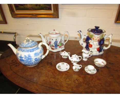 A 19th century porcelain teapot of square lobed shape enamelled in the Chinese style with figures in garden, a pottery toby c