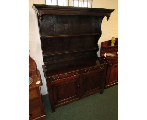 17th century Welsh oak canopied dresser, the upper section with two plate racks, the lower section with two drawers and two c