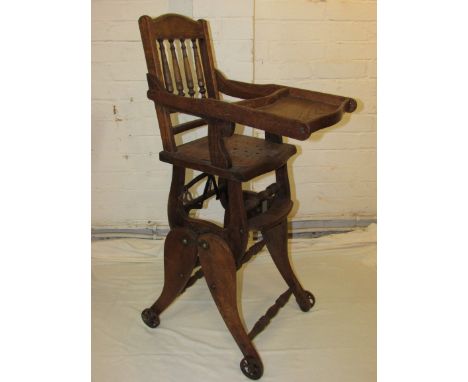 Oak metamorphic child's chair / high chair standing on iron wheels, circa 1900 with some more recent bracing, height to back 