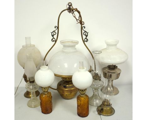 A large hanging brass oil lamp with glass shade, and seven other oil lamps (8) 