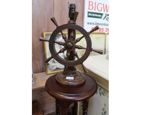 A WOODEN TABLE LAMP fitted with a revolving ships wheel 