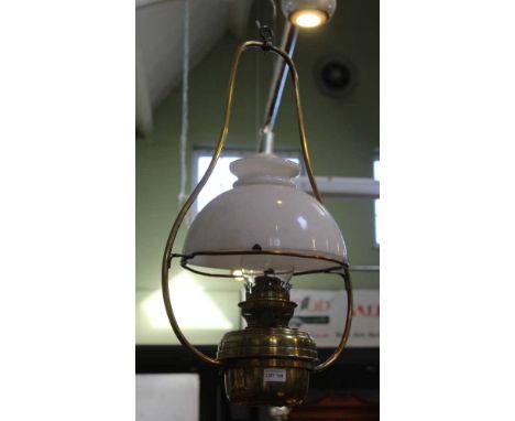 A HANGING BRASS OIL LAMP with milk glass shade 