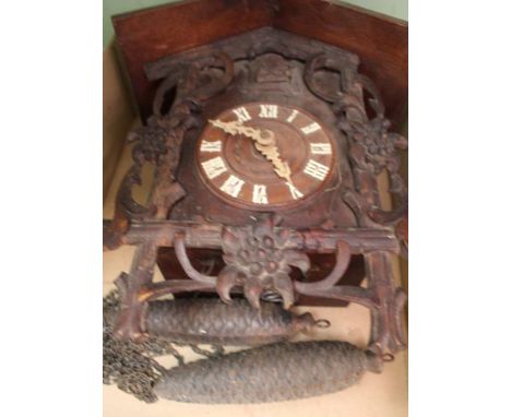 A BOX CONTAINING A CARVED WOODEN TYPICAL CUCKOO CLOCK with pendulum and weights 