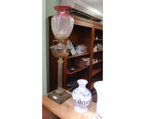 AN EARLY 20TH CENTURY CAST BRASS BASED OIL LAMP with textured glass shade 