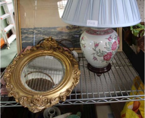 A FANCY GILT FRAMED OVAL BEVEL PLATE WALL MIRROR together with a rose decorated ceramic base table lamp and a machine woven t