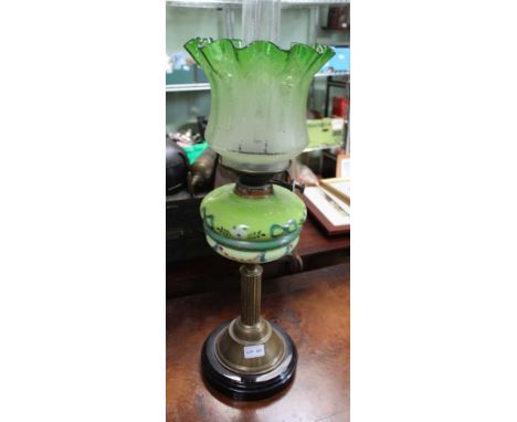 A BRASS COLUMNED OIL LAMP with painted reservoir and tinted shade 