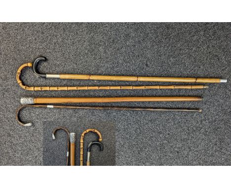 Four Vintage Walking Sticks, comprising a bamboo stick, and three silver topped canes.