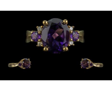9ct Amethyst &amp; Diamond Ring, the large oval Amethyst surrounded by two smaller Amethysts and four small diamonds.  Ring s