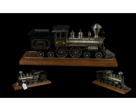 Novelty Table Lighter in the Form of a Steam Train, steel model train with a plaque inscribed 1864, raised on a wooden base. 