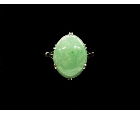 An 18ct white gold and jade oval cabochon ring, with six double claws and with pierced shoulders, size N 1/2, approx 4.3g.