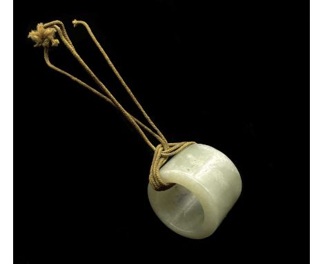 A Chinese jade archer's ring, probably 18th century, with remnants of thread still attached, diameter 28mm, width 24mm.Condit