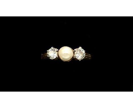 A yellow metal diamond and pearl ring, the central cultured pearl flanked by twin claw set diamonds, each weighing approx 0.2