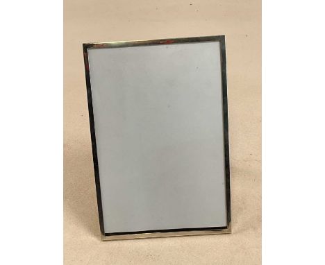 SANDERS &amp; MACKENZIE; a large George V hallmarked silver photograph frame of plain rectangular form, with wooden easel bac